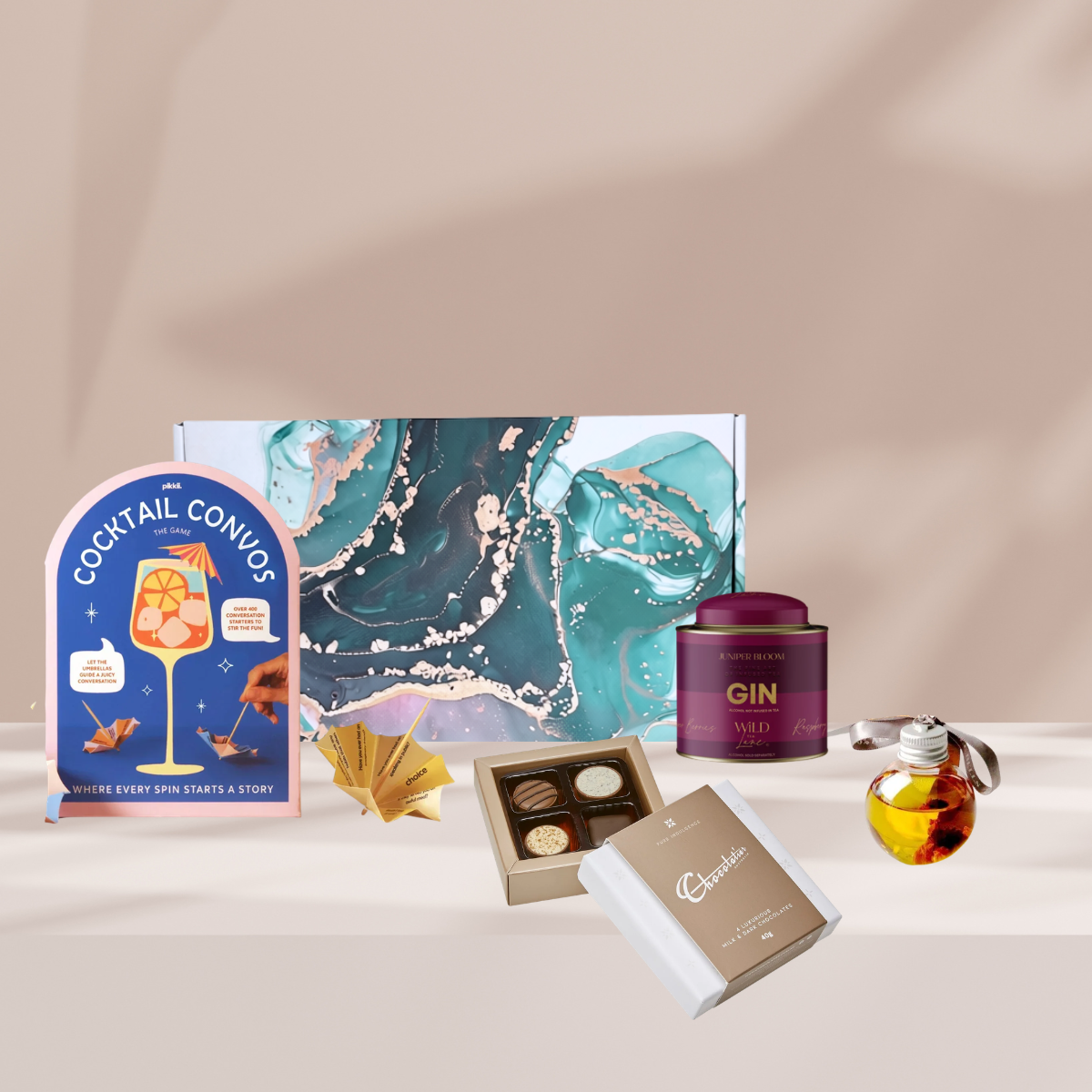 Festive Sips Christmas gift hamper featuring Wildlane Tea Gin, Cocktail Convos, gin baubles and a Chocolatier chocolate box