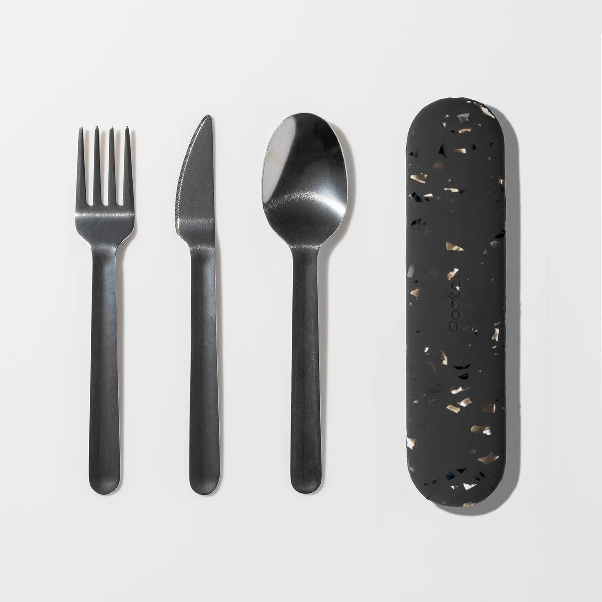 A flat-lay of a four-piece metal cutlery set with a Charcoal terrazzo-patterned protective case on a clean white background.