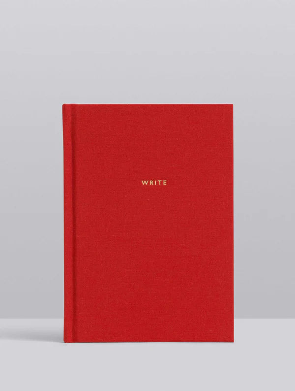 Red notebook with 'WRITE' on a gray background