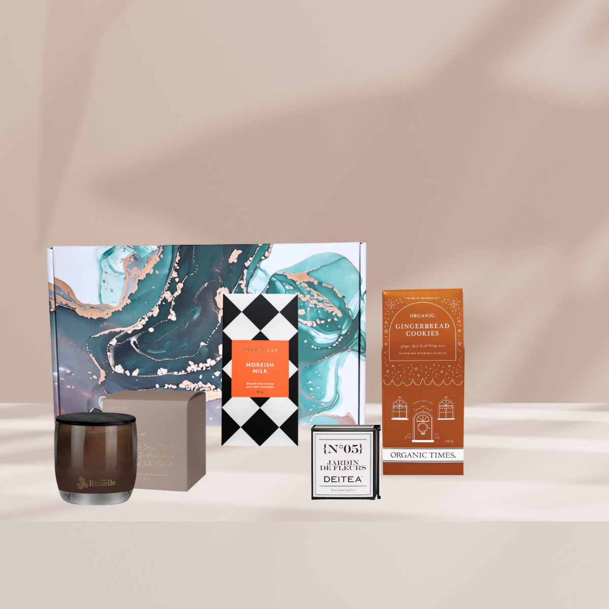 Cosy Christmas gift hamper featuring gingerbread cookies, an Urban Rituelle Spiced Tonka 140g candle, a Koko Black Moreish Milk Chocolate Block and a Deitea Mini Tea