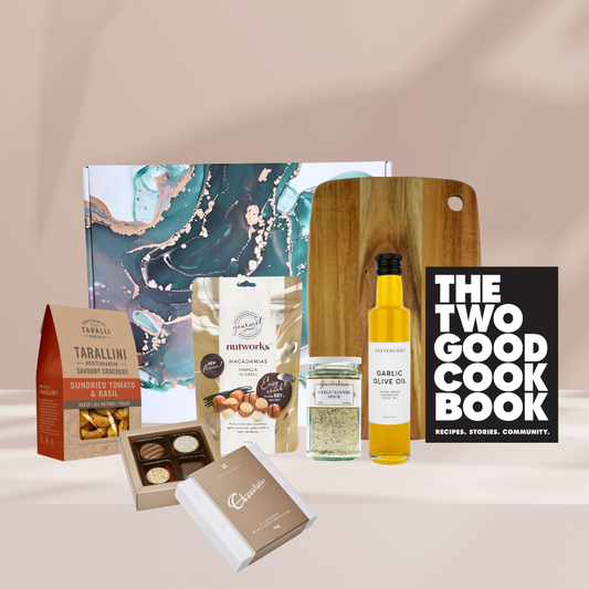 gourmet cooking hamper featuring a cookbook, garlic olive oil, tarallini biscuits, Nutworks, Gewürzhaus garlic salt, a Miei branded chopping board and a Chocolatier mini gift box.