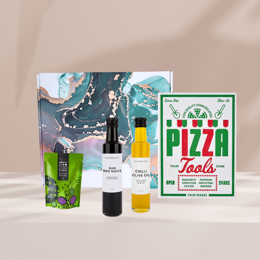 The Gourmet Slice gift hamper featuring Printworks The Essentials Pizza Tools, Tasteology Rum BBQ Sauce, Tasteology Chilli Olive Oil and Mount Zero Olives (80g).