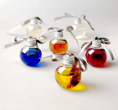 Colorful gin in glass bottles with liquids inside, each tied with a silver ribbon